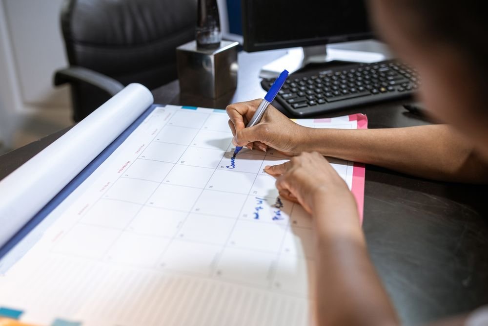 Person marking a calendar to plan a bathroom remodel timeline