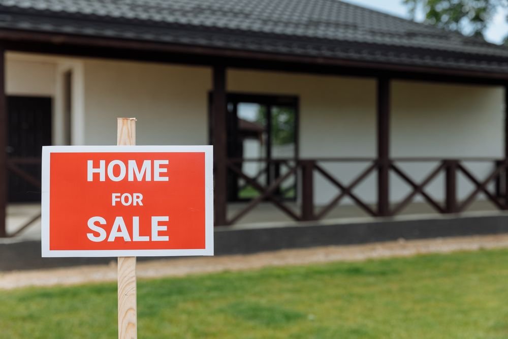 Home for sale sign representing the decision to move