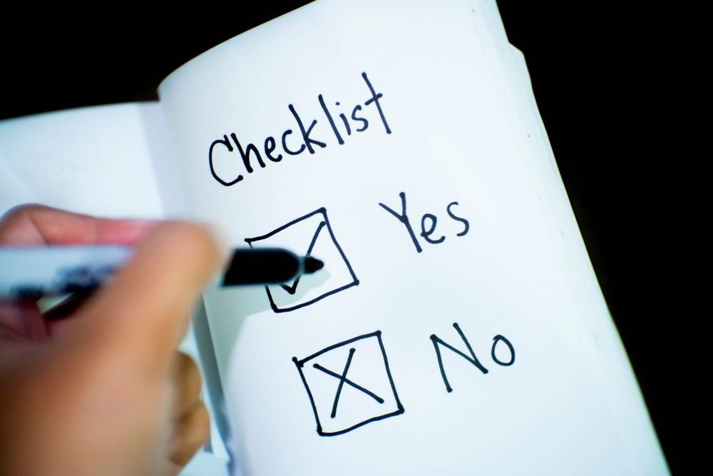 Person marking a checklist while deciding whether to renovate or move